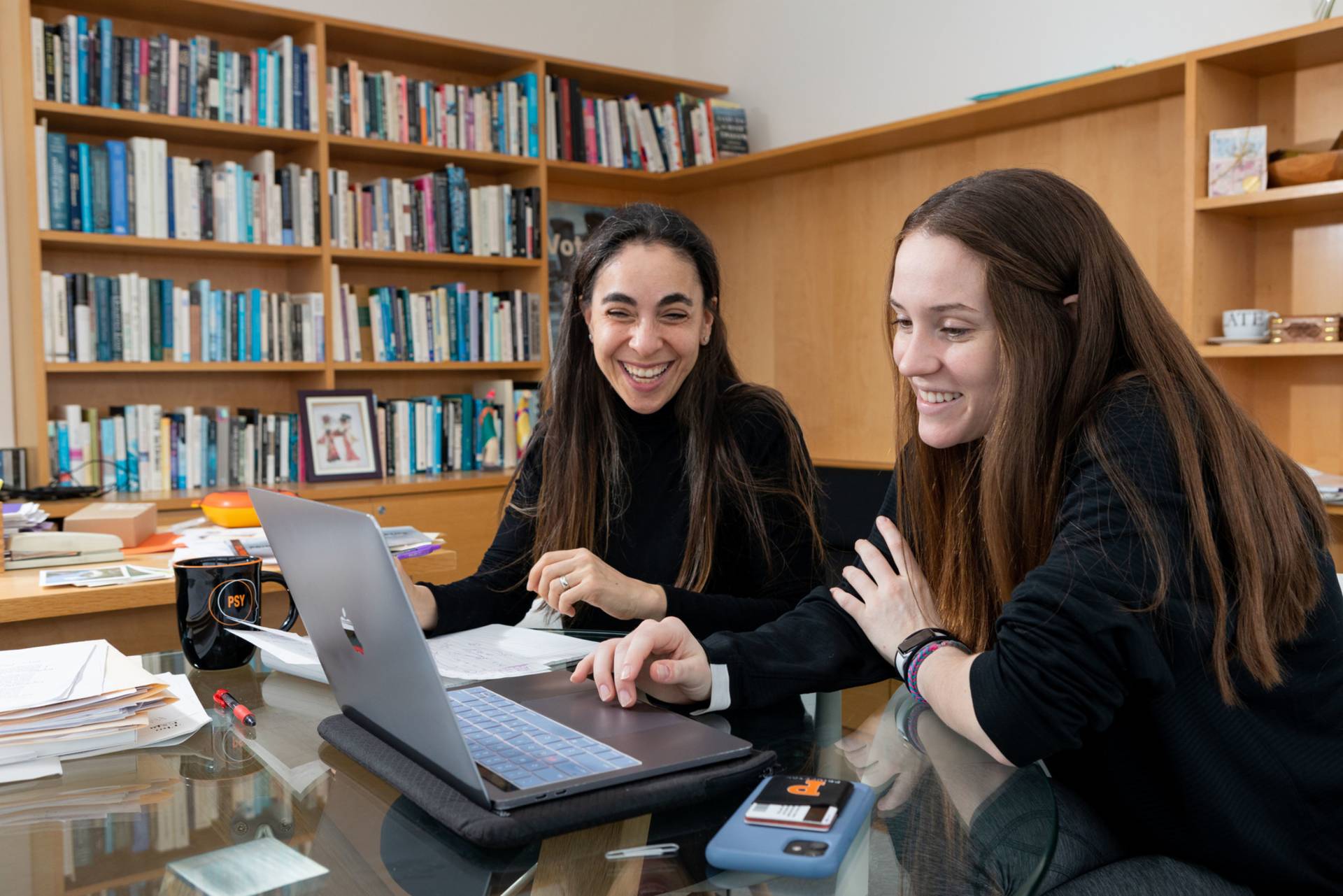 Student at laptop conferring with professor