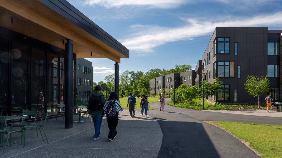 Graduate students walk outside the Meadows Apartments