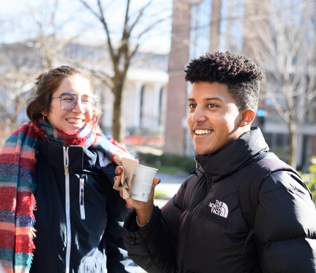 Student with cofee cup and another on a cold day