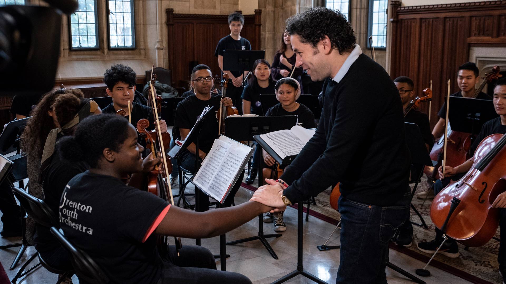 Gustavo Dudamel shaking hands with violinist