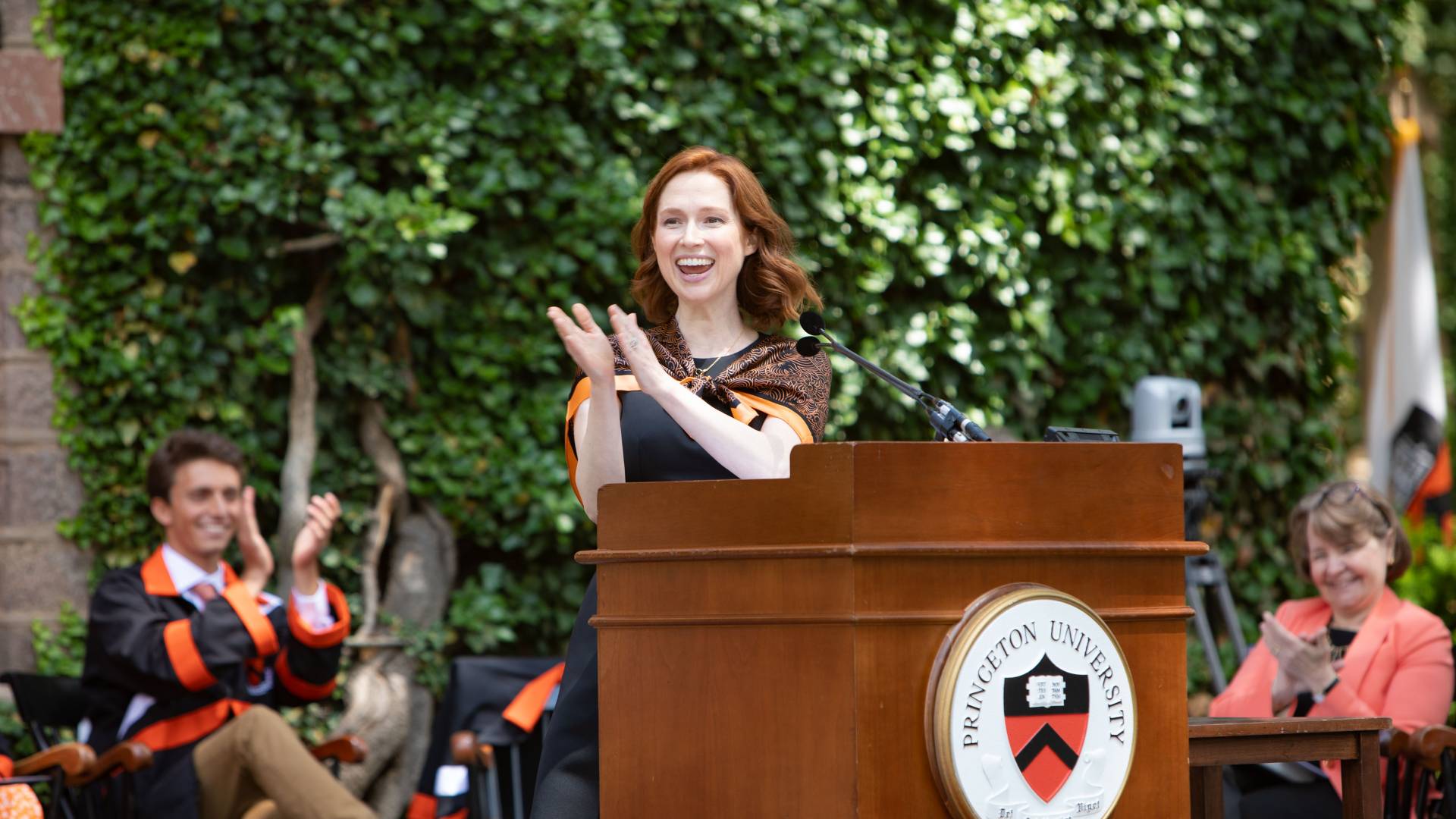 Ellie Kemper claps and laughs at the podium
