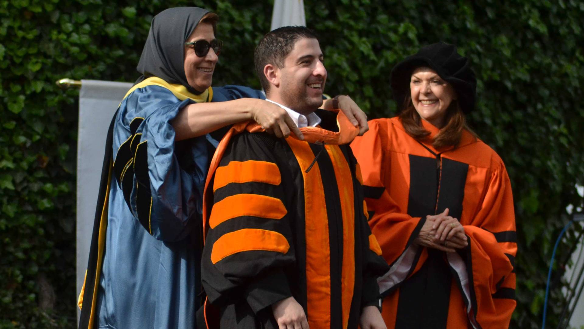 A student is hooded by Amaney Jamal, his advisor