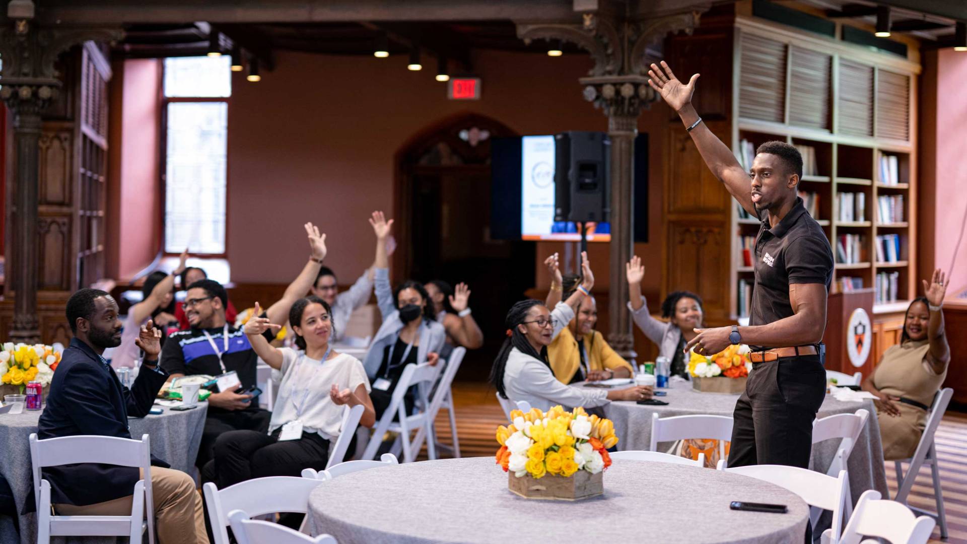 graduate attendees raise their hands durning a seminar