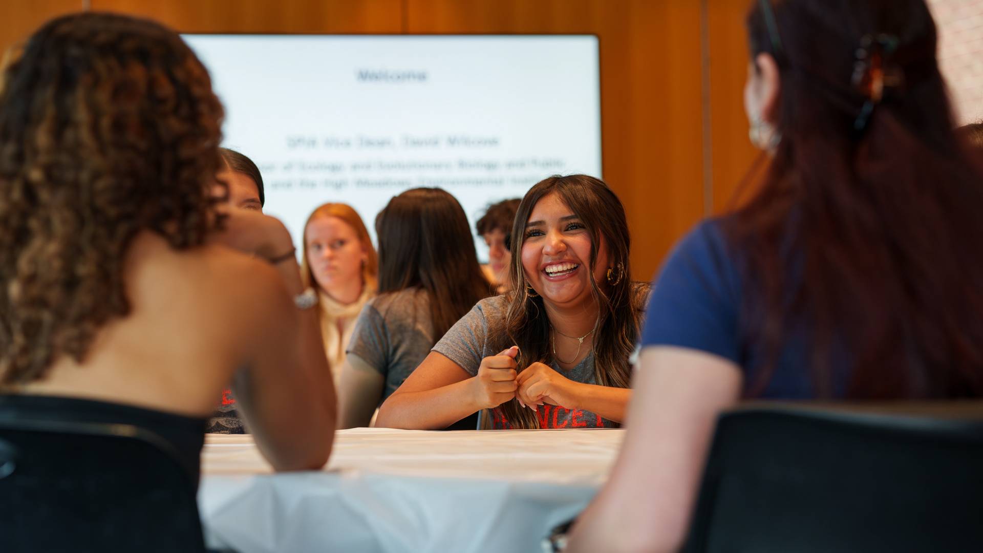 Students smiling seated around a table