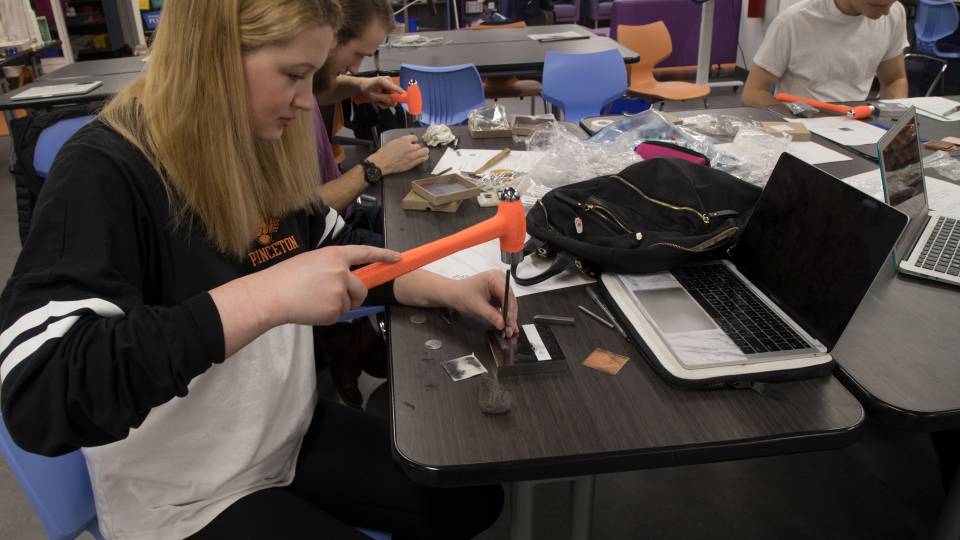 Carley Stamps using hammer to make viking-inspired jewelry