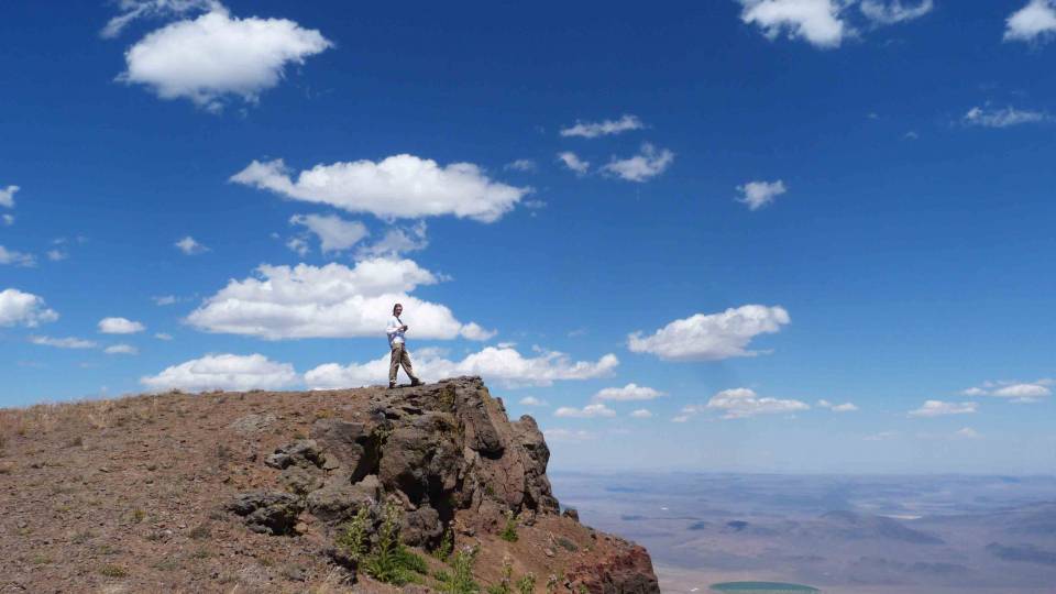 Jennifer Kasbohm, a graduate student in geosciences, stands on a layer of soft red ash on Steens Mountain in Oregon