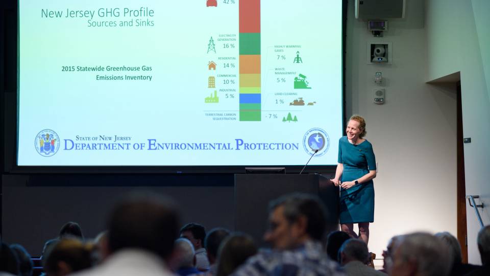 Debbie Mans standing in front of a screen giving a lecture
