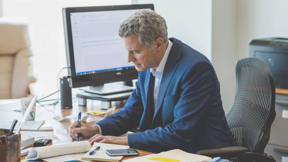 Alan Krueger writing at his desk.