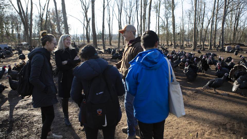 Carruth and the farmer laugh as the 3 students prepare to record their interview