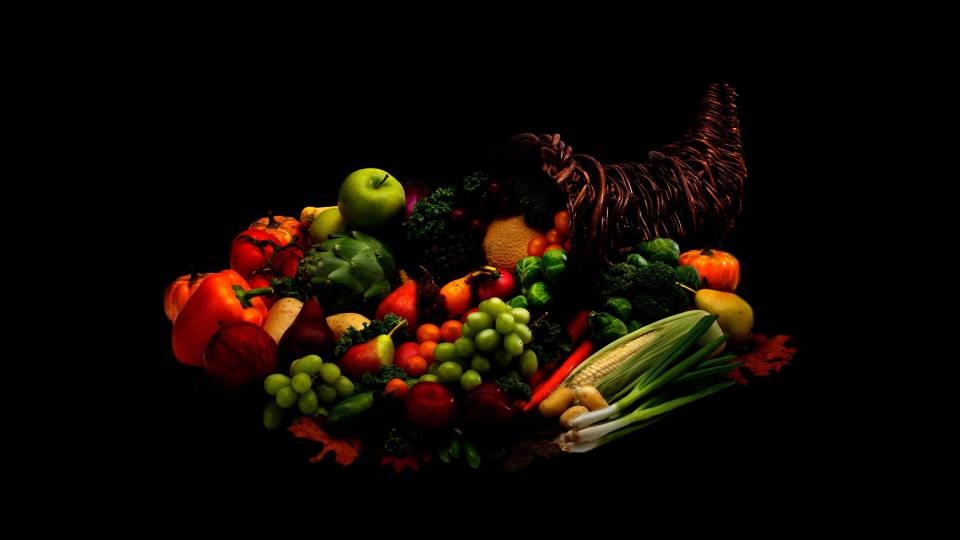 A conical basket is filled with a bounty of fruit and vegetables