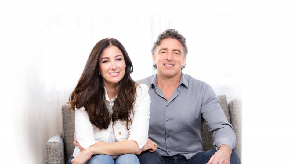 A man and a woman sit on a sofa