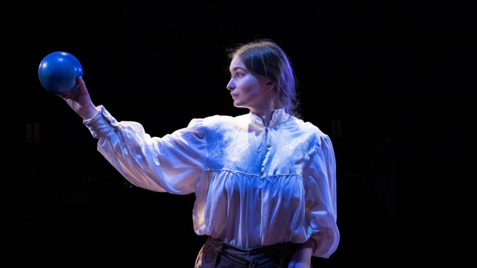 Student actor holding a blue ball