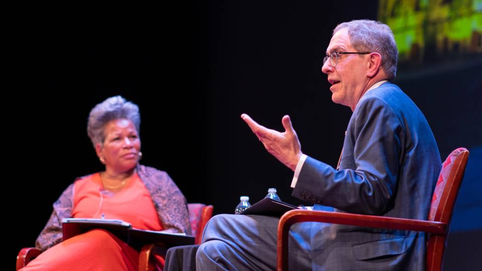 Christopher L. Eisgruber and Rochelle Calhoun sitting on stage