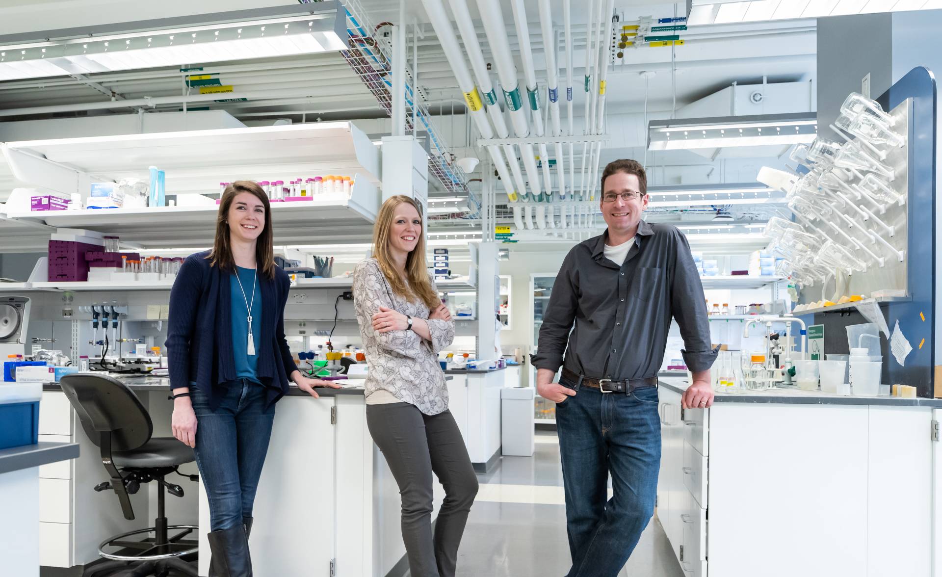 Allison Murawski, Theresa Barrett and Mark Brynildsen standing in a lab