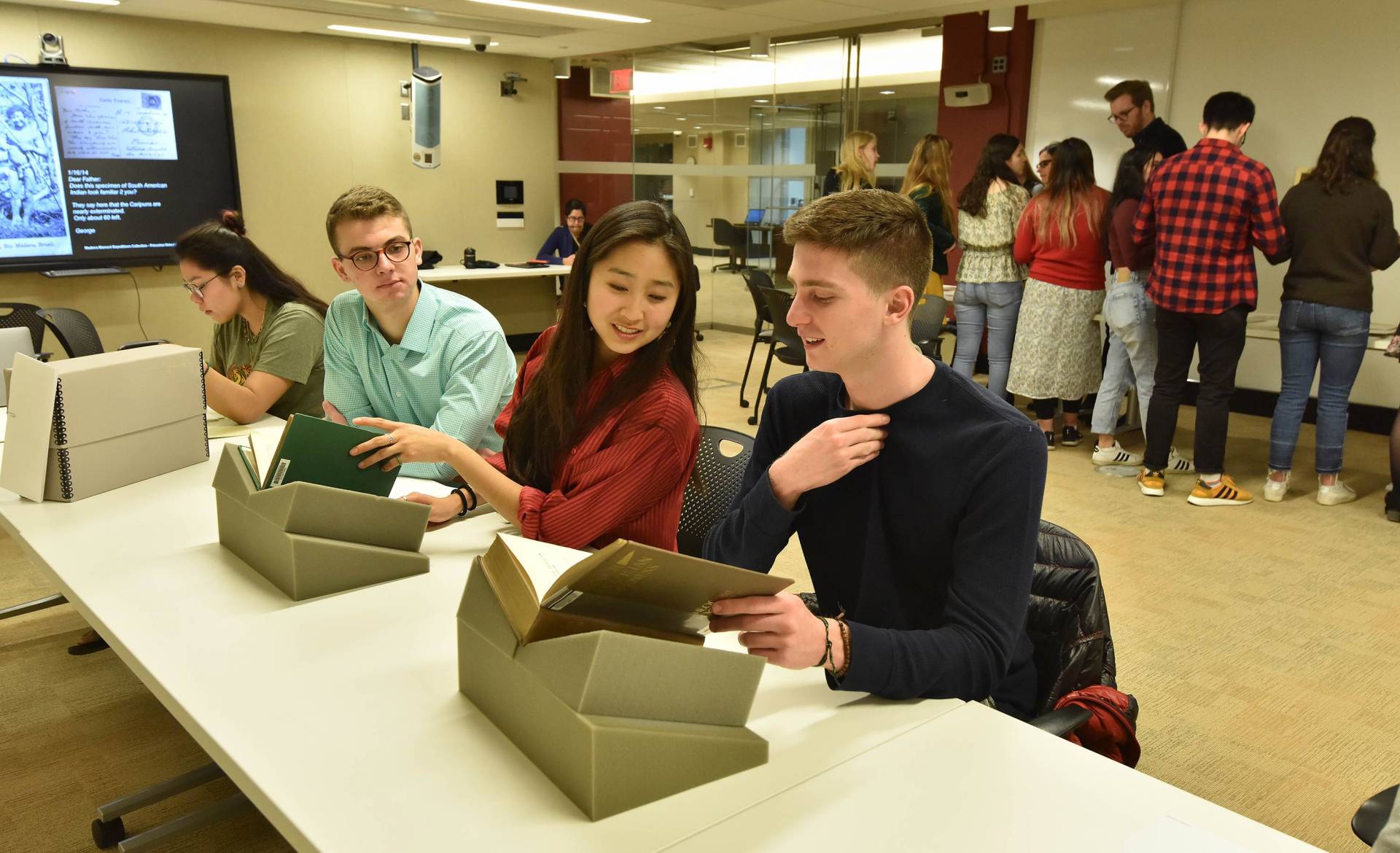 students examining documents in the library