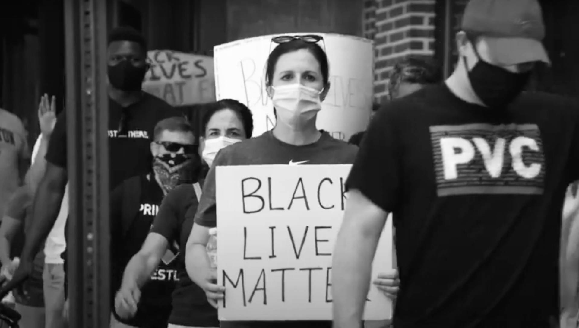 masked protesters holding up signs that read "Black Lives Matter"