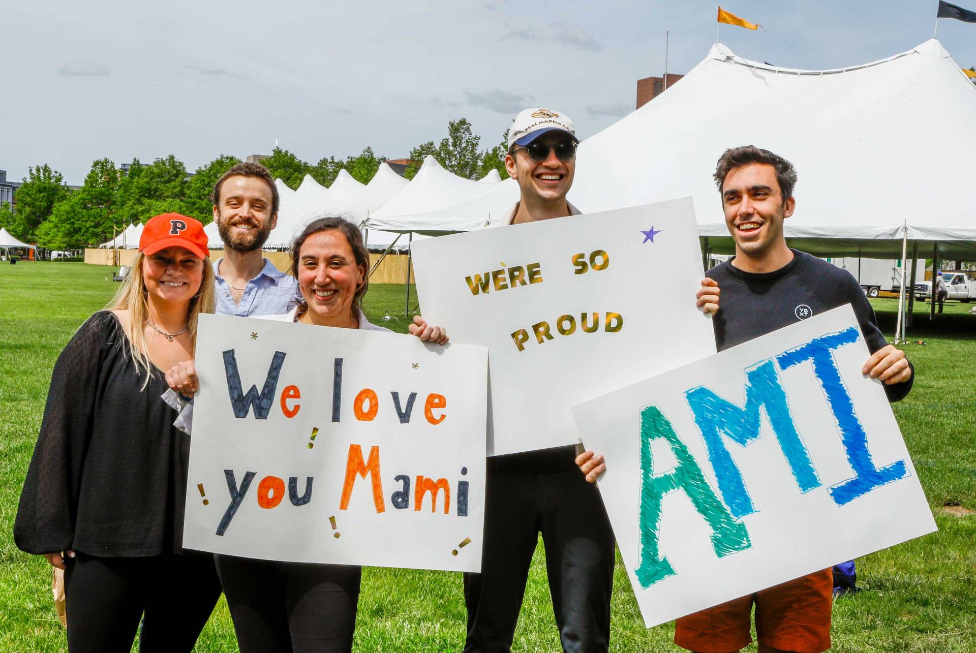 Freiends and family hold signs that say "We love you Mami"