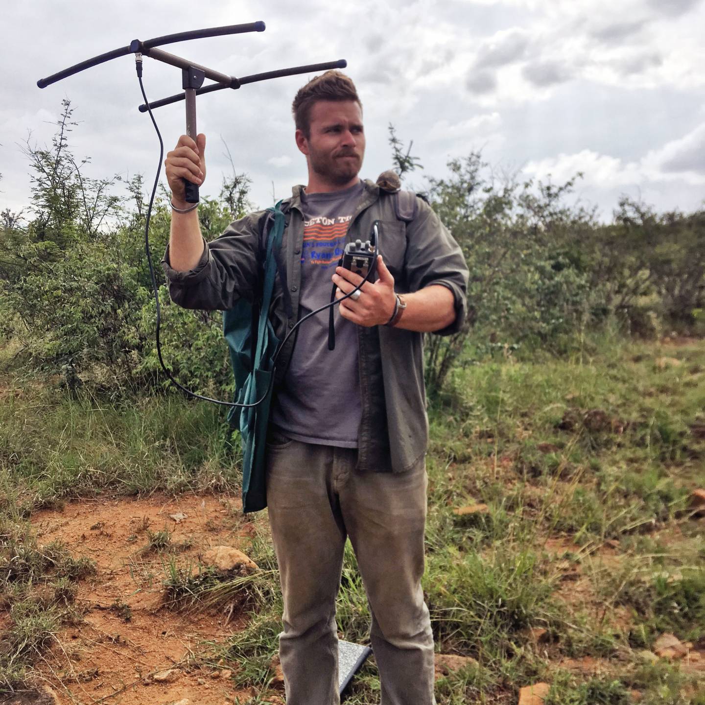 Daniel Petticord holding a VHF radio antenna and a baby tortoise