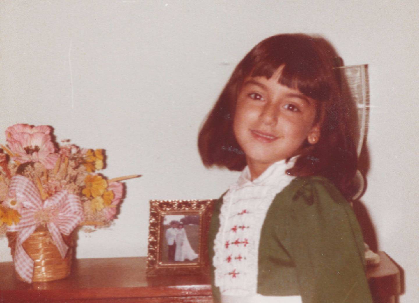 Araoz as a child, in front of her parents' wedding portrait
